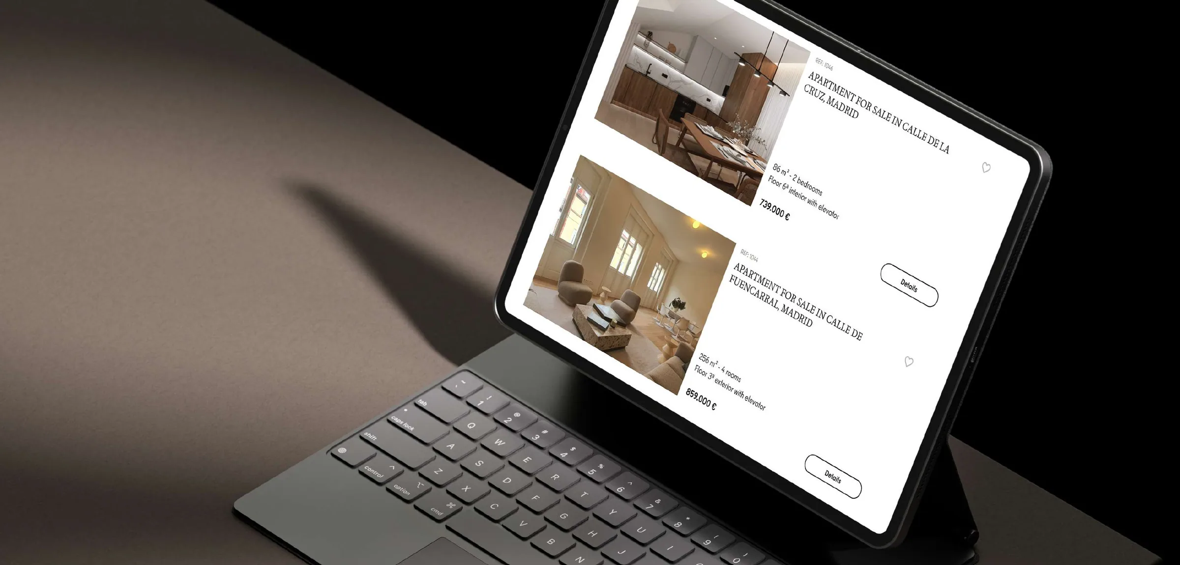 A tablet on a dark desk showing PeterJohns apartment listings